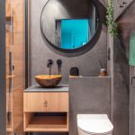 Malá kúpeľňa so sivým obkladom, závesnou skrinkou s umývadlom a sprchovým kútom