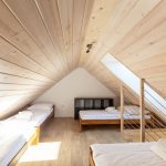 podkrovná spálňa s dreveným obkladom na strope v chate v Nízkych Tatrách v rezorte Tri vody