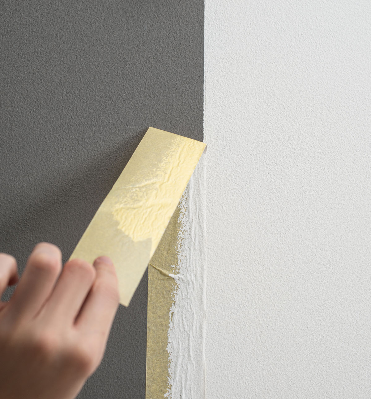 odliepanie krycej pásky po maľovaní steny
