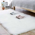biely koberec s dlhým vlasom pred posteľou