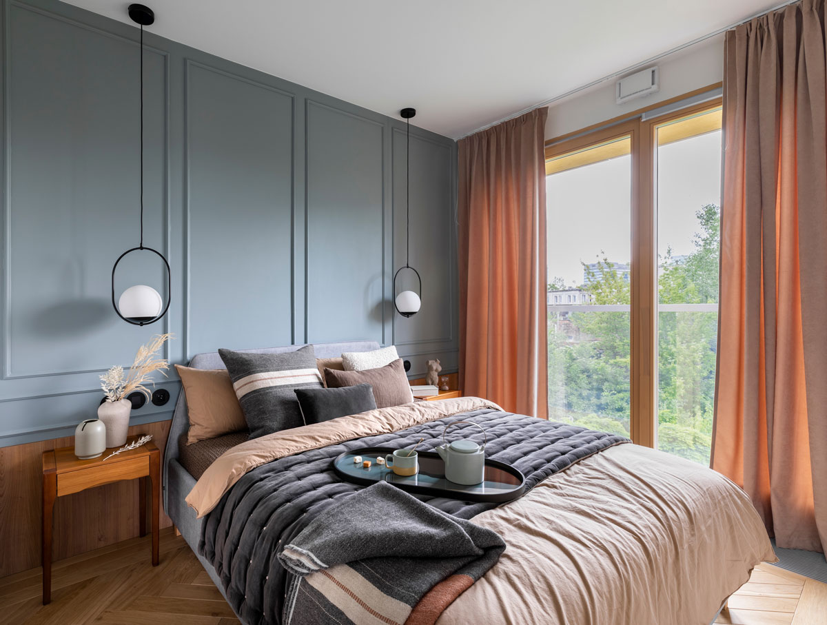 elegantná spálňa s ozdobnými lištami na stene a výhľadom z postele von oknom